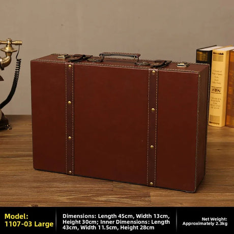 Brown leather suitcase on a wooden surface with books and a phone in the background