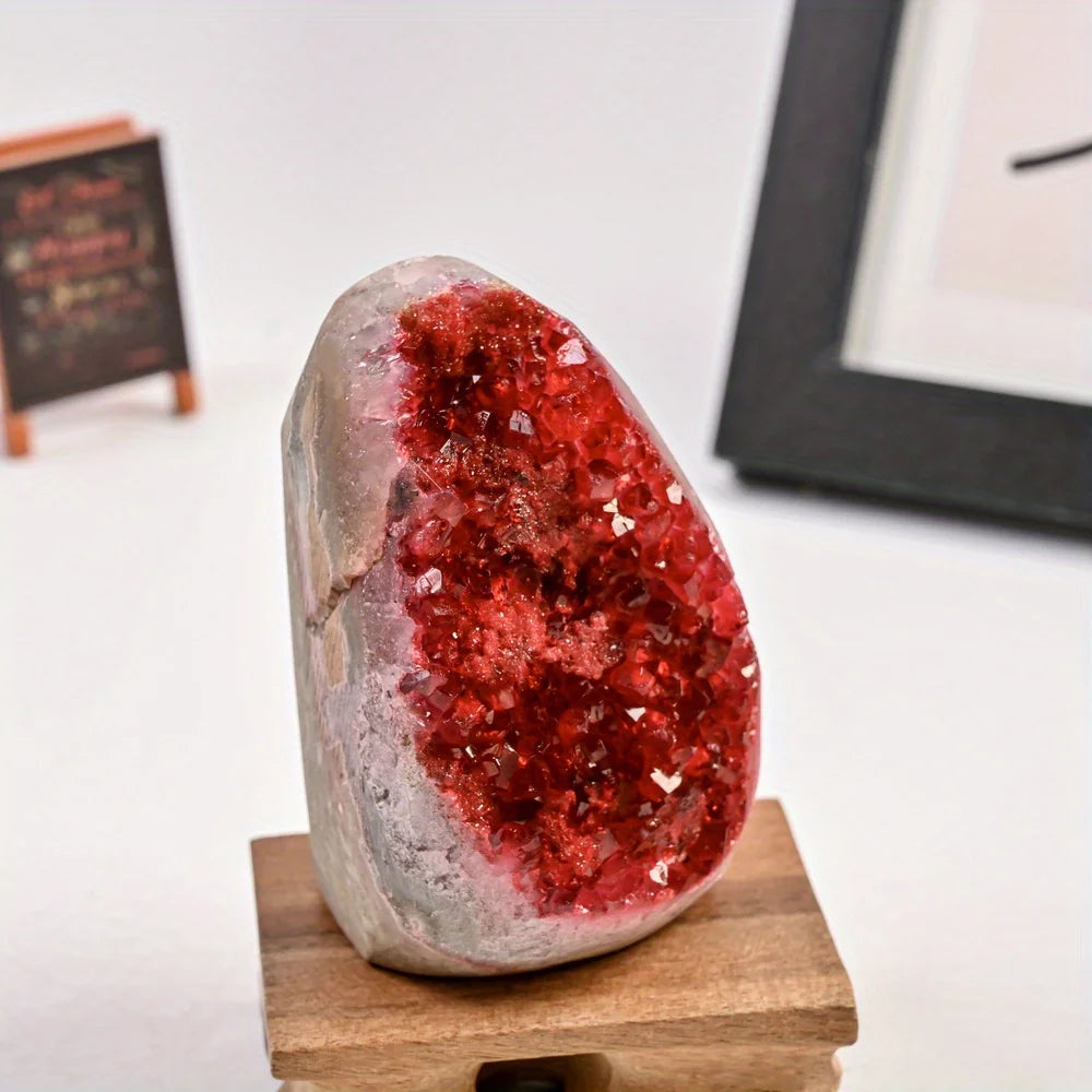 Red crystal geode on a wooden stand with a blurred background