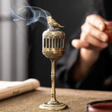 Bronze incense burner with smoke on a textured surface