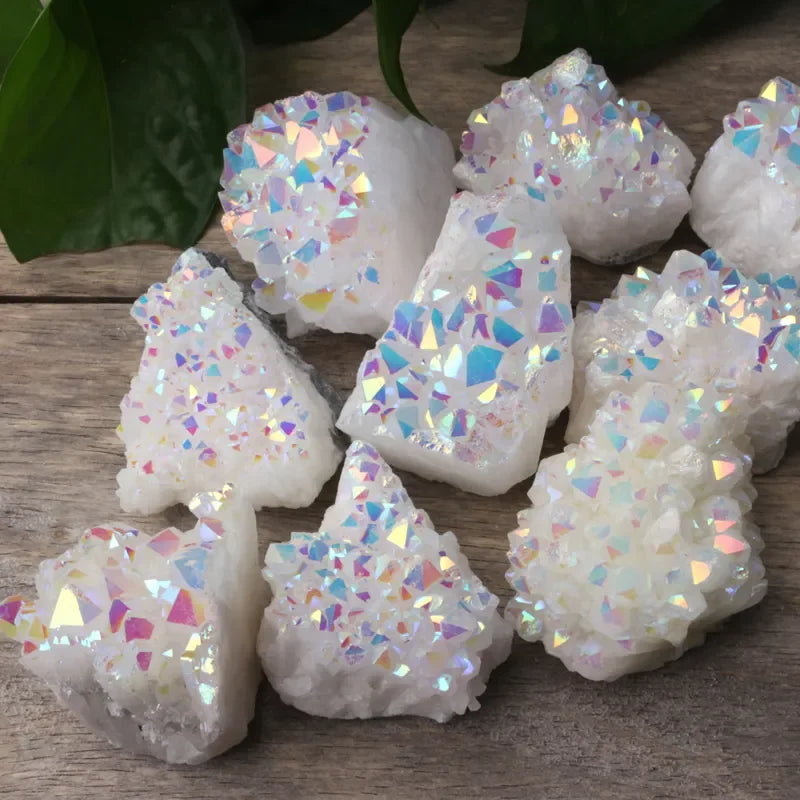 Iridescent crystal-like objects on a wooden surface with green leaves in the background