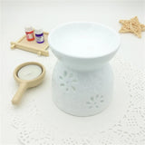 White ceramic diffuser with floral patterns on a textured surface