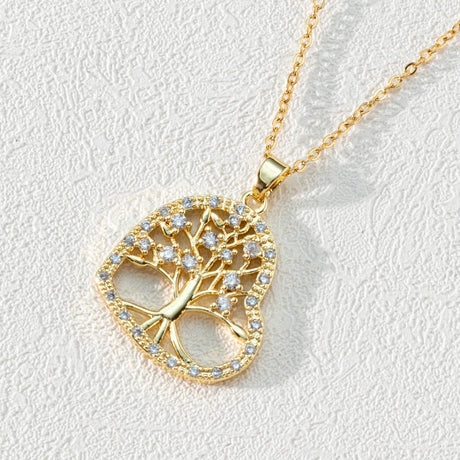Gold tree-shaped pendant necklace on a light gray background