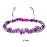 Purple beaded bracelet with gold accents on a white background