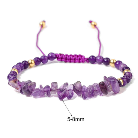 Purple beaded bracelet with gold accents on a white background