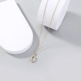 Gold necklace with a pendant on a white surface