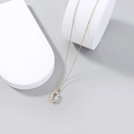 Gold necklace with a pendant on a white surface