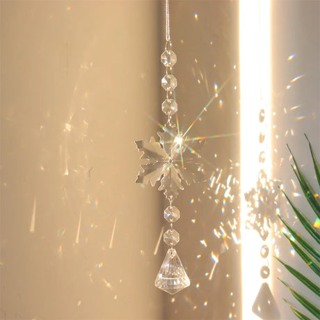 Crystal snowflake ornament with sunlight and plant in the background