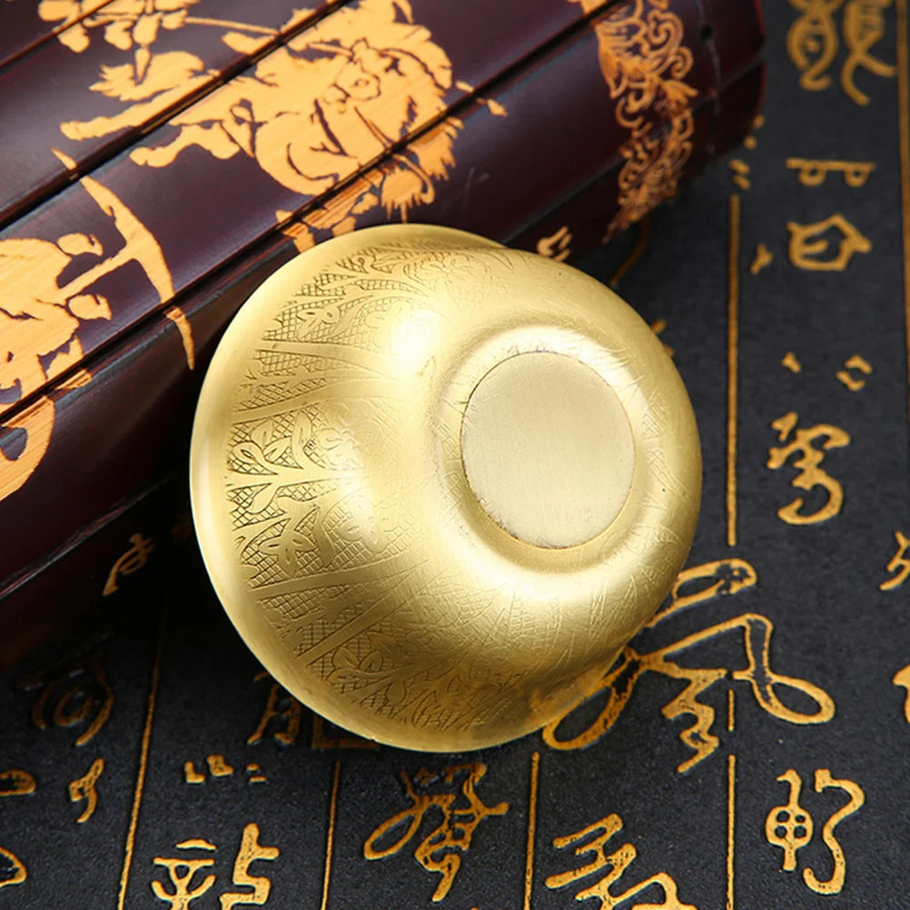 Gold fidget spinner on a dark surface with gold patterns and text