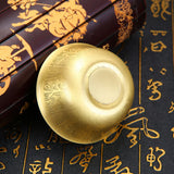 Gold fidget spinner on a dark surface with gold patterns and text