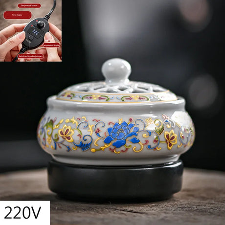 Decorative ceramic warmer with floral patterns on a dark surface, inset showing a temperature control device.