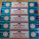 Multiple boxes of Satya Nag Champa Money Matrix incense on a wooden surface