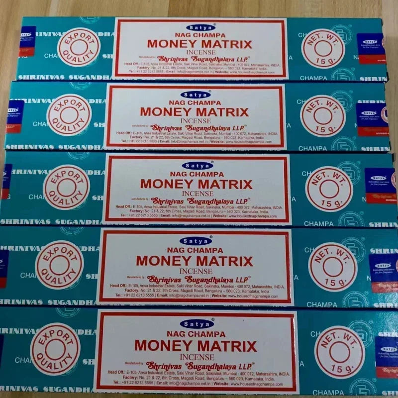 Multiple boxes of Satya Nag Champa Money Matrix incense on a wooden surface