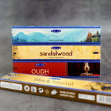 Satya incense sticks packaging with sandalwood, oudh, and black sandalwood scents on a gray background.