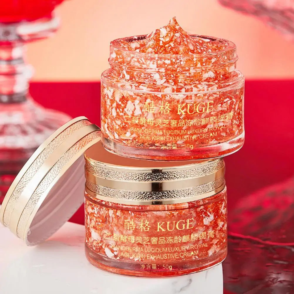 Two jars of KUGE cream with a red and gold design on a blurred background