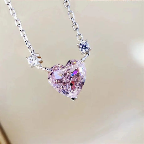 Heart-shaped pink gemstone necklace on a blurred background