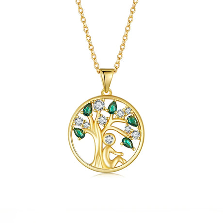 Gold tree-shaped pendant necklace with green and clear gemstones on a white background