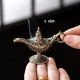 Small ornate lamp being held with smoke emerging, labeled 's size'.