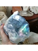 Crystal rock held in a hand with a blurred background