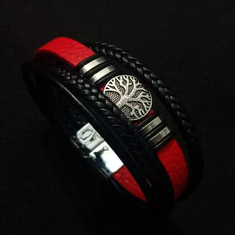 Black and red braided bracelet with a silver tree of life design on a dark background