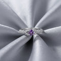 Silver ring with a purple gemstone on a white background