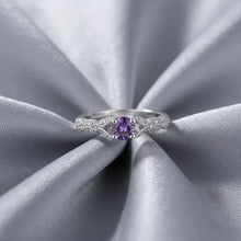 Silver ring with a purple gemstone on a white background