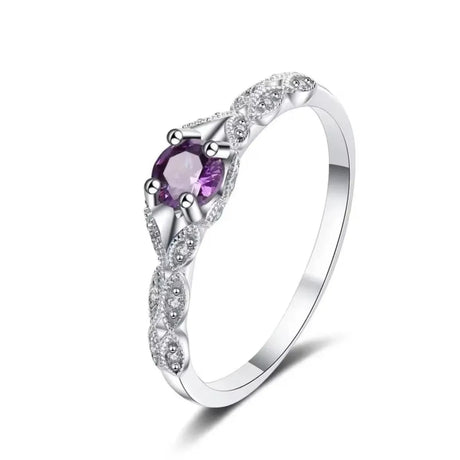 Silver ring with a purple gemstone on a white background