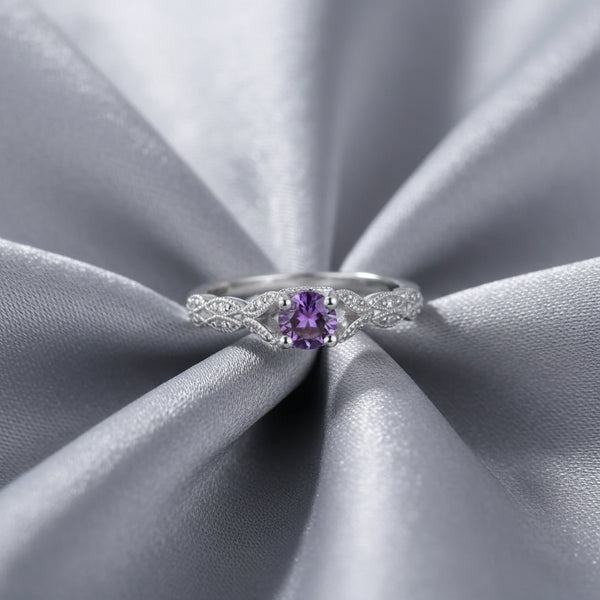 Silver ring with a purple gemstone on a white background