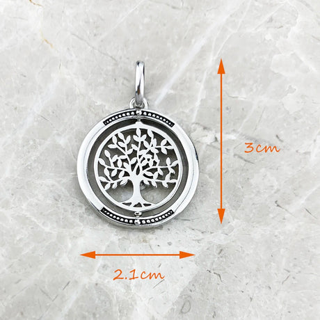 Silver tree of life pendant with measurements on a textured white background