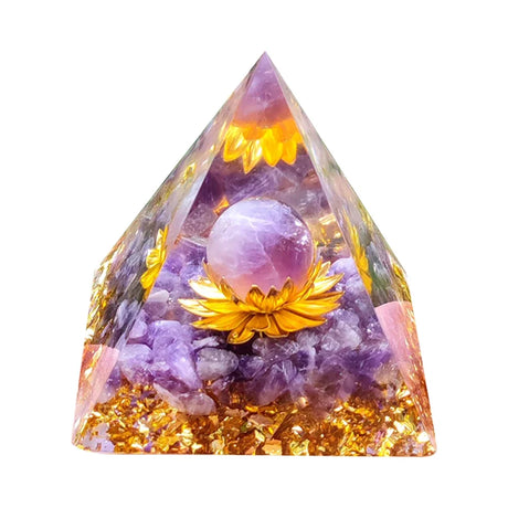 Pyramid-shaped crystal with purple sphere and yellow flowers on a white background