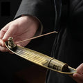 Person holding a traditional bow with a dark background