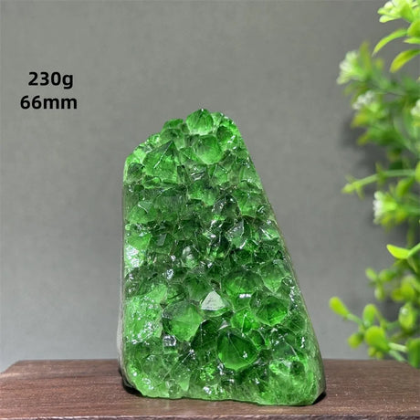 Green crystal rock on a wooden surface with a gray background