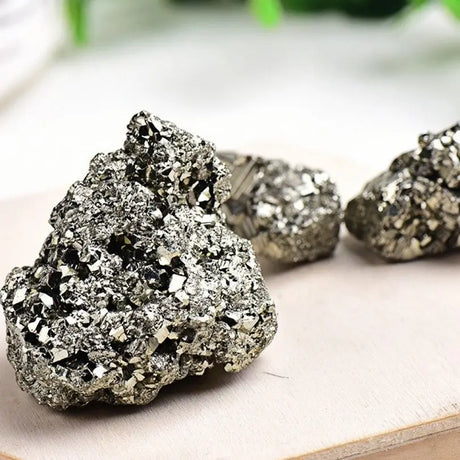 Close-up of pyrite crystals on a light wooden surface