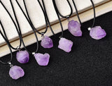 Purple crystal necklaces on black cords with a book in the background, branded 'AierCrystal'.