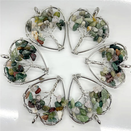 Five tree-shaped stone pendants on a white background