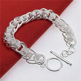 Silver bracelet with intricate design on a red and white background