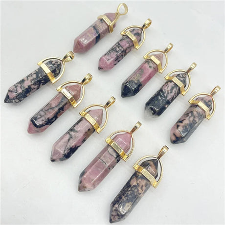 Collection of stone pendants with gold accents on a light gray background