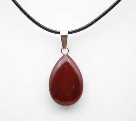 Teardrop-shaped red pendant on a black cord against a white background