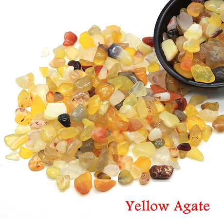Yellow agate stones with a bowl of stones on a white background