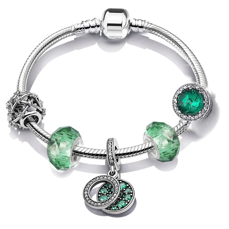 Silver bracelet with green gemstone charms on a white background