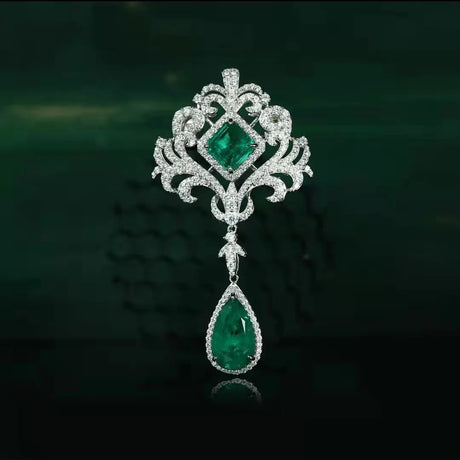 Ornate brooch with emerald stones on a dark background