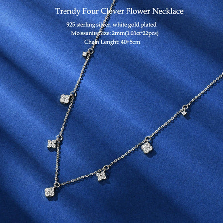 Silver necklace with clover pendants on a blue fabric background