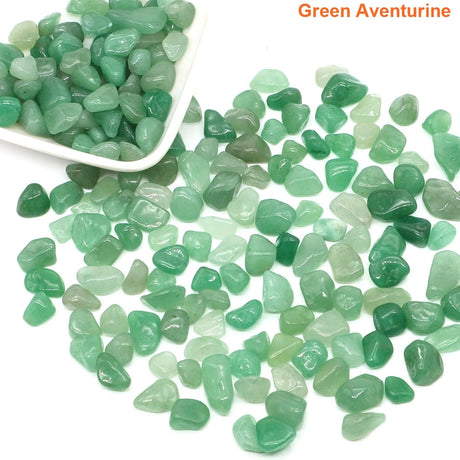 Green aventurine stones with a white scoop on a white background