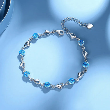 Silver bracelet with blue gemstones on a light blue background