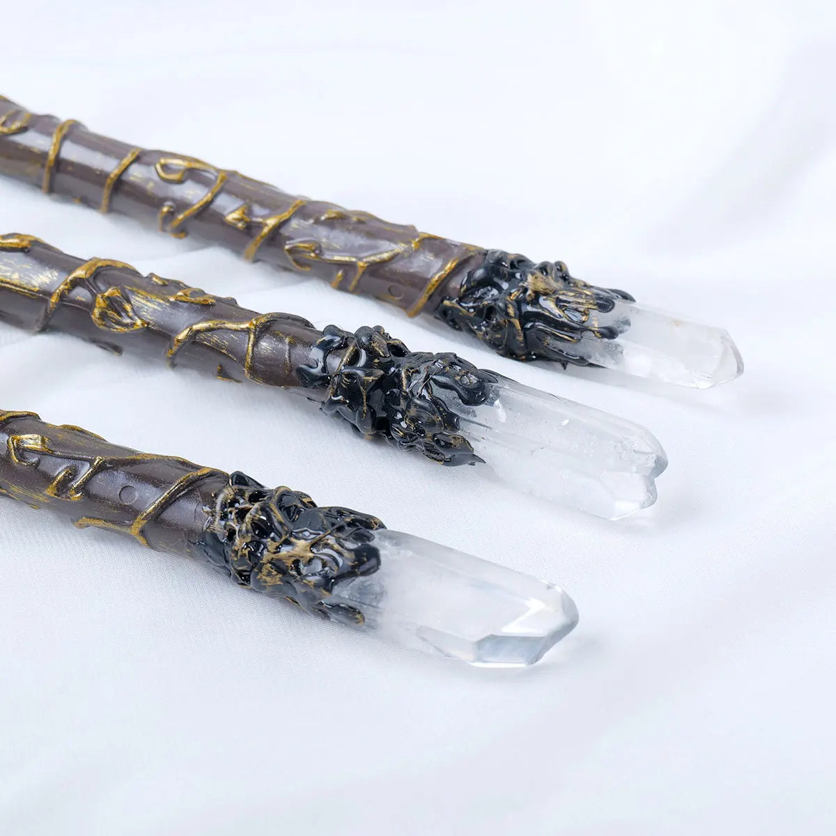Three decorative sticks with crystal tips on a white background