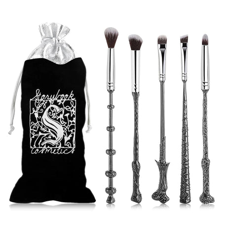 Set of makeup brushes with decorative handles resembling wands, next to a branded black pouch.