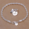 Silver bracelet with charms on a beige background