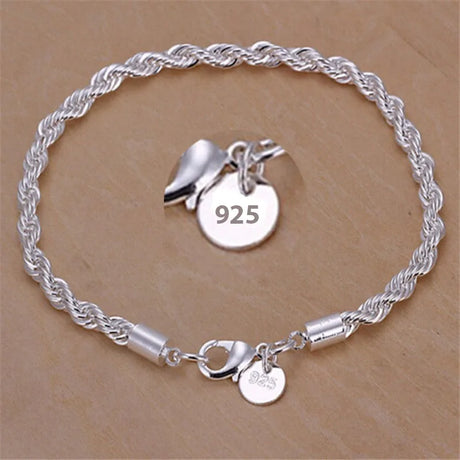 Silver bracelet with charms on a beige background