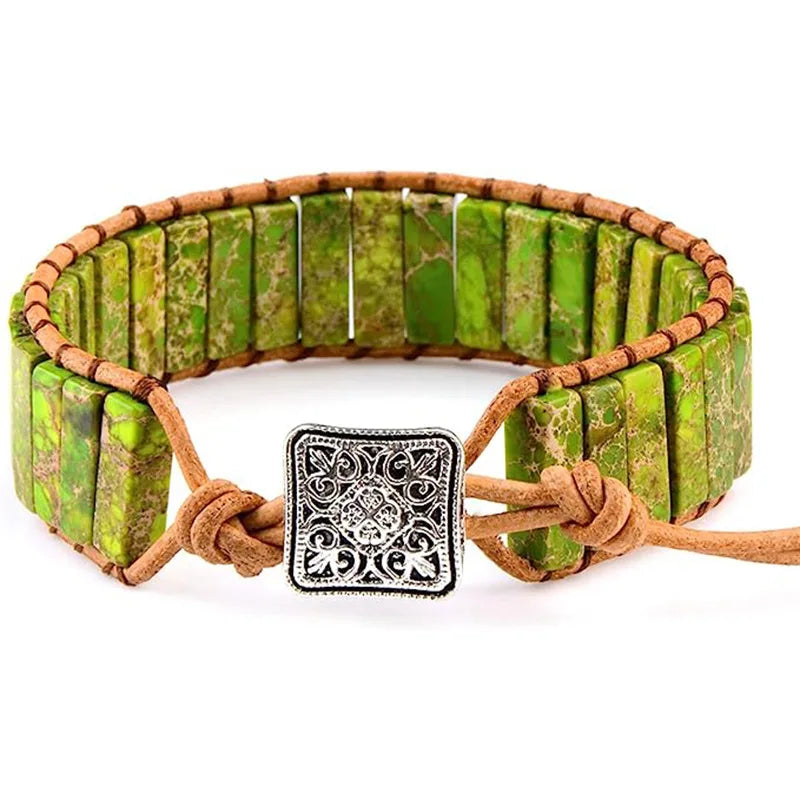 Green stone bracelet with brown leather strap and decorative clasp on a white background