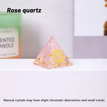 Pyramid-shaped rose quartz crystal on a white surface with a blurred background