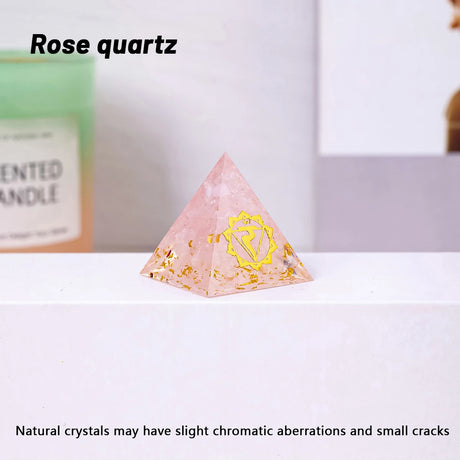 Pyramid-shaped rose quartz crystal on a white surface with a blurred background